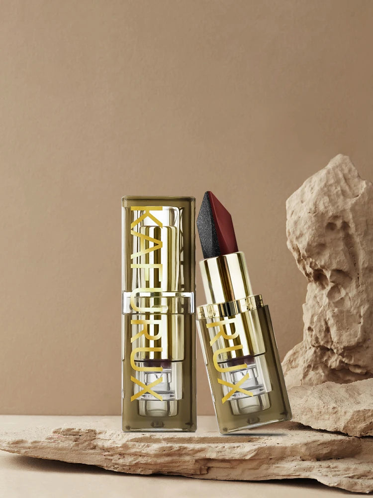 Luxury gold tube of Kafurux two-tone lipstick with matte and shimmer finish displayed on natural rock background
